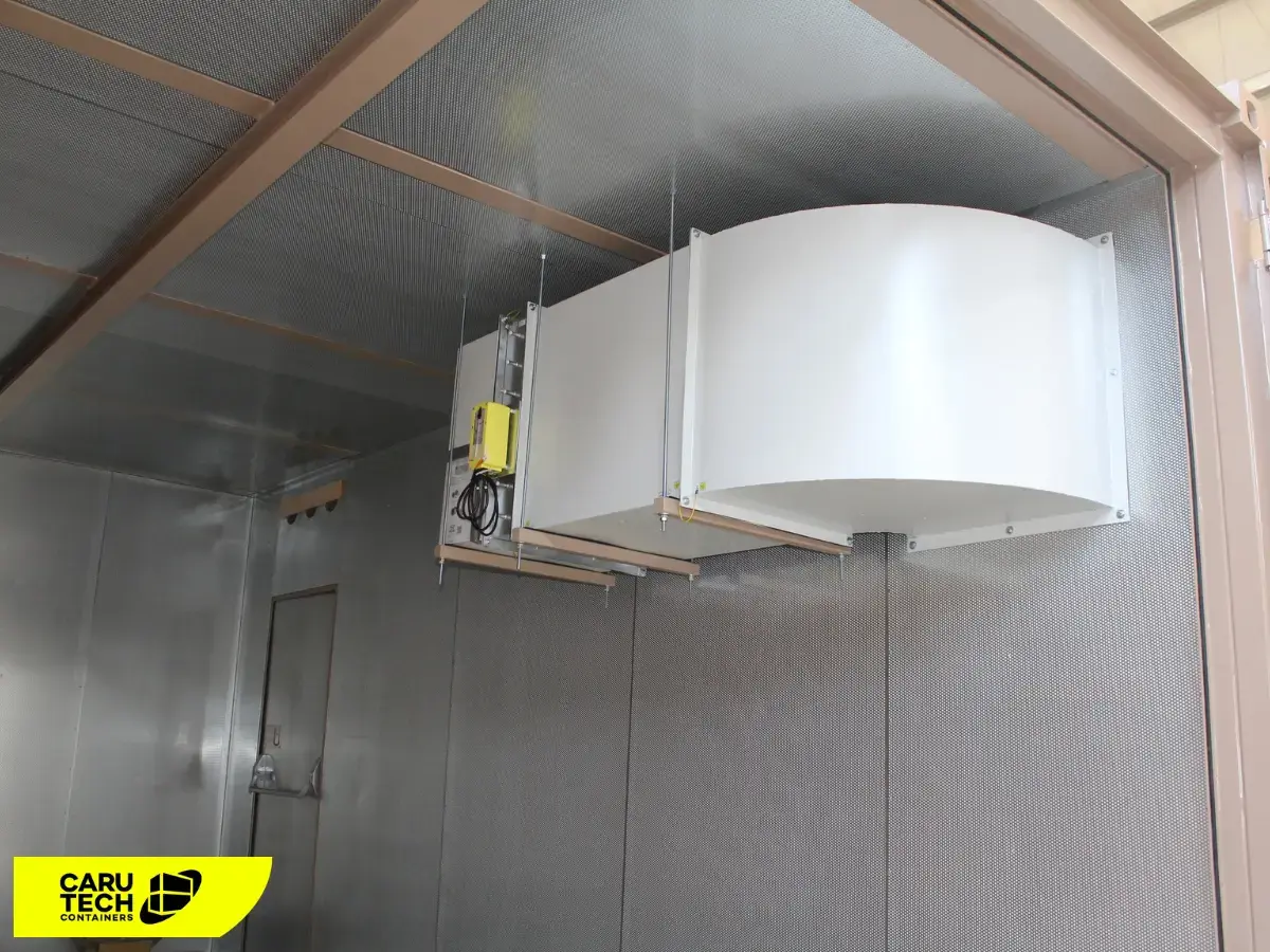 Innenansicht eines Technikcontainers mit installierter Klimaanlage und Luftführungssystem zur kontrollierten Kühlung von elektrischen Komponenten